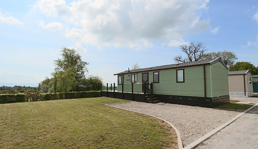 green caravan with a small garden next to it