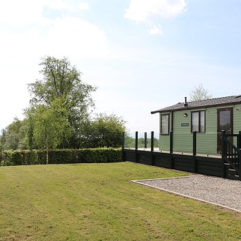 green static caravan with a garden next to it