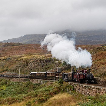 Train on the tracks through mountains